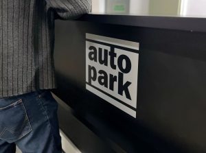 Homem aguardando atendimento na recepção de estacionamento de automóveis, promovendo terceirização de estacionamento eficiente.