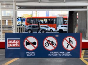 Estacionamento com sinalização de restrições e área de entrada para veículos, destacando local onde abrir estacionamento para carros.