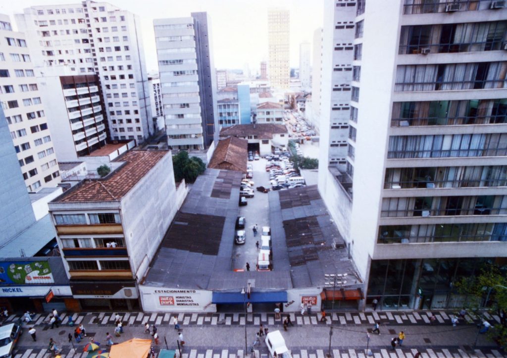 Vista aérea de ruas entre prédios no centro da cidade, com a placa de estacionamento na primeira unidade da história autopark no estacionamento Santa Cecília.