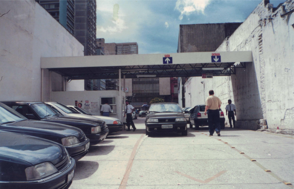 Entrada de estacionamento em área urbana com pátio de veículos na Unidade Marechal, em Curitiba, retratando a implantação de pátios em eixos comerciais no anos 90 da Autopark Marechal.
