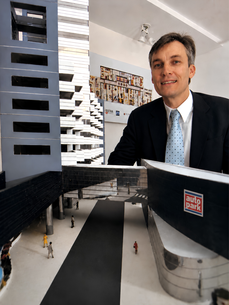 Claudio Roth jovem ao lado da maquete do Edifício Curitiba Park & Business (CP&B) da Autopark, em foto de apresentação do projeto.