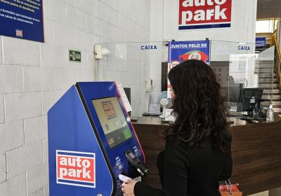 Mulher realizando um pagamento automatizado em um caixa de autoatendimento Autopark.