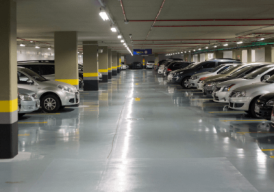 Imagem de um amplo e organizado estacionamento com diversos modelos de veículos estacionados, mostrando diferentes tipos e marcas de carros.